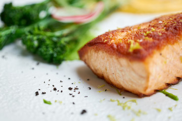 Salmon steak fillet and garnished with young broccoli. Restaurant menu, a series of photos of different dishes