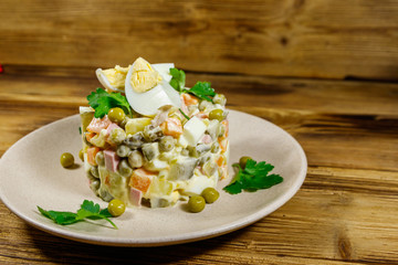 Traditional Russian festive salad Olivier on wooden table