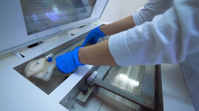 Clinic worker puts bags with plasma onto a laboratory machine.