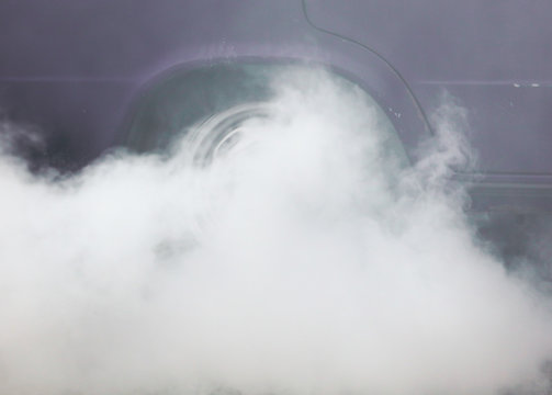 Smoke from under the wheels of a car