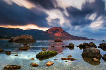 Fototapeta na wymiar Sunset on the rocky shore of tropical sea