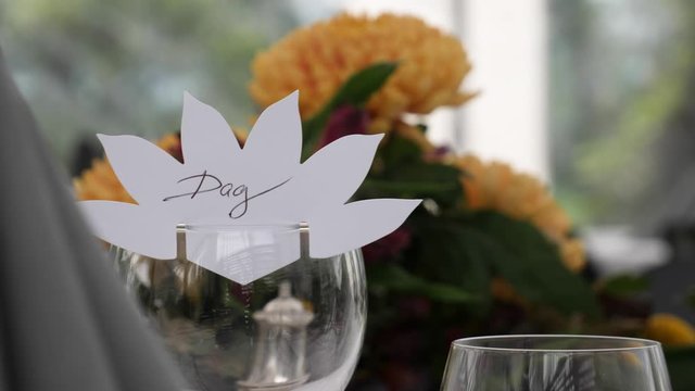 Teble setting before the start of a celebration dinner event such as a wedding or anniversary with flower centerpeice