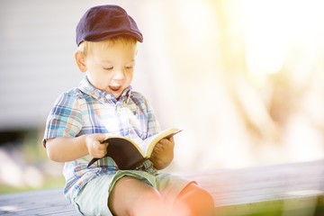 Closeup shot of a surprised child reading the bible with a blurred background
