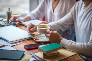 Interior designer drinking cappuccino while sitting near wife