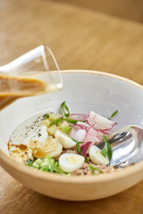 Soup okroshka. Traditional Russian summer cold dish with kvass in bowl on wooden background. Restaurant menu