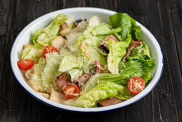 greek salad on black wooden background