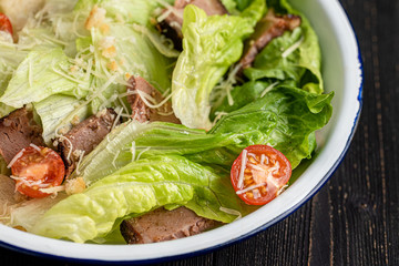greek salad on black wooden background
