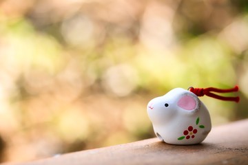 A cute looking Japanese good luck charm rat for celebrating year of the rat on green background.