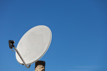 Satellite dish antenna on blue sky