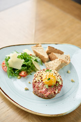 Beef tartar in the restaurant. Tasty dish on a plate. Restaurant menu.