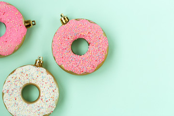 Christmas tree toys, bright donuts, pink and white, on a blue background, top view
