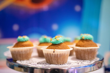 Delicious Christmas cupcakes on holiday table with cream with stars. Shallow depth of field