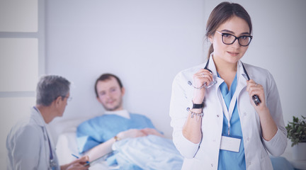 Doctor checking heart beat of patient in bed with stethoscope