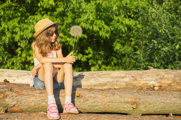 Obraz premium Summer outdoor portrait of romantic girl with big fluffy dandelion