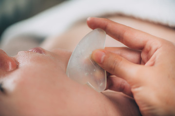 Guasha Face Sculpting Technique with Jade Stone in Beauty Salon © Microgen