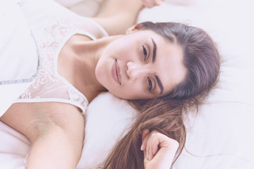 Fototapeta na wymiar beautiful young woman basking in bed in the morning. Beautiful
