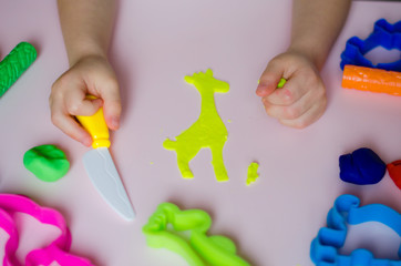 Child hands playing with colorful clay. Homemade plastiline. Girl molding modeling clay. Homemade clay. Child playing and creating from play dough.