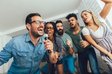 Happy friends singing together at home. Karaoke party concept - Powered by Adobe