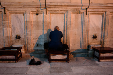 Man performing ablution during sunset (maghrib) in Istanbul, Turkey
