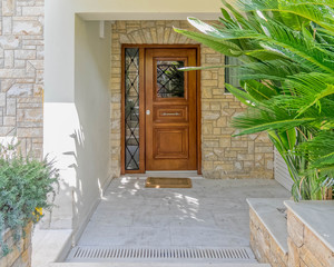contemporary house entrance portico with natural wood door and stone covered wall
