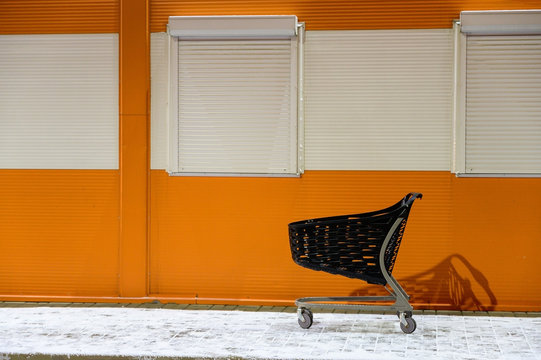 The concept of the modern shopping center. Photo of a street of a store with a stroller against the background of store walls.
