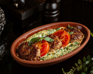 kookoo dish with eggs and herbs served with cotlets and tomato