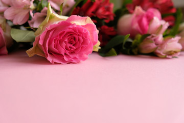 Fototapeta premium Frame with bouquet of flowers on pink background.