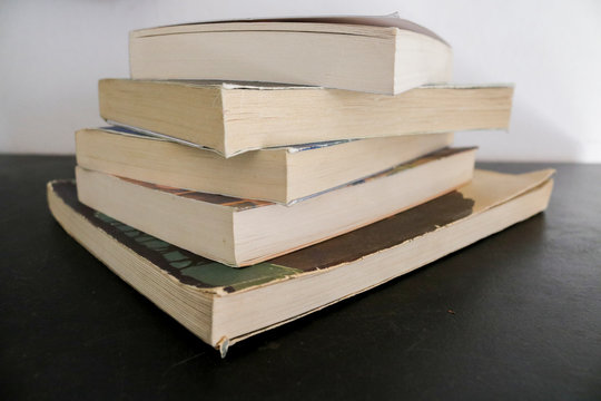 Raccolta di vecchi libri accatastati su un tavolo nero, educazione e letteratura