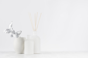 Contemporary dressing table with blank white bottles, beige bungs, silver branch, bowl as elegant home decoration, copy space.