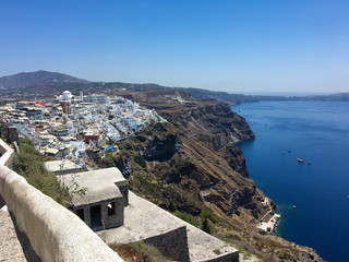 Ancient greek volcanic island from above. Roofs of houses on the mountain against the background of the sea
