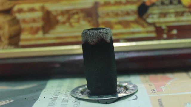 Close up shot of dhoop batti / incense stick burning with some smoke on the pooja room