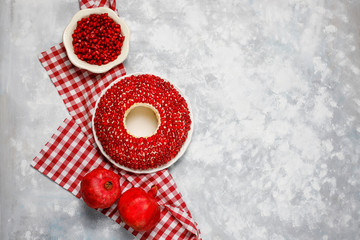 Salad Garnet bracelet. Vegetable salad with pomegranate seeds with pomegranate on concrete background