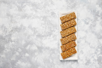 Granola bar. Healthy sweet dessert snack. Sesame, peanut, sunflower in honey. Gozinaki is Georgian national food, oriental sweet. Top view on concrete background
