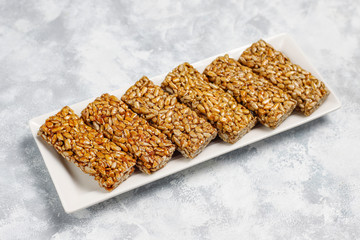 Granola bar. Healthy sweet dessert snack. Sesame, peanut, sunflower in honey. Gozinaki is Georgian national food, oriental sweet. Top view on concrete background