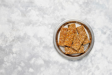 Granola bar. Healthy sweet dessert snack. Sesame, peanut, sunflower in honey. Gozinaki is Georgian national food, oriental sweet. Top view on concrete background