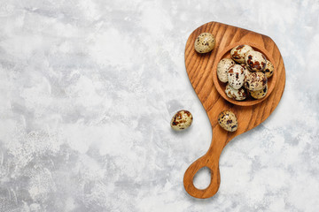Quail eggs on a white-grey concrete  background