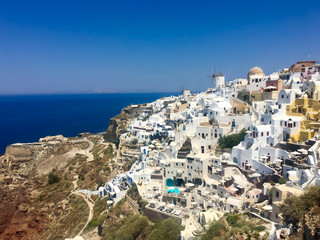 Fototapeta na wymiar Ancient greek volcanic island from above. Roofs of houses on the mountain against the background of the sea