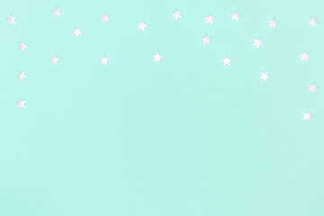 New year, Christmas frame, greeting card. White stars on pastel blue background. Top view, flat lay, copy space