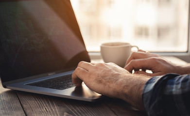 Home office workplace. Man looking at graph on laptop analysis sitting in the home office