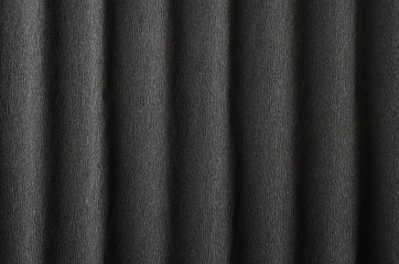 Black crepe paper background with vertical waves and a small pattern for your creative tasks.
