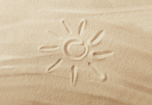 sun drawing on the beach sand