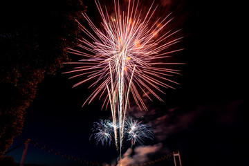 Fireworks light up on dark sky background.