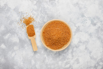 Brown sugar in ceramic plate on concrete background,top view