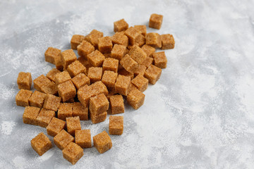 Brown sugar cubes on concrete background,top view