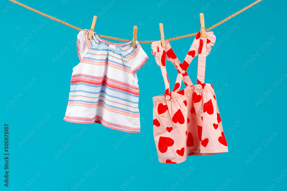 Wall mural Clothesline with pinned baby clothes close up - Wall murals