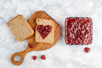 homemade raspberry jam with fresh raspberries on concrete background,top view