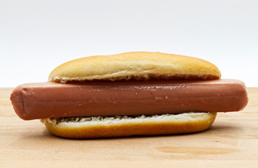 Fresh hot dog, wooden table, white background