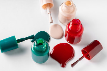 Several opened bottles of nail polish on white background
