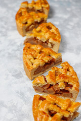 Homemade pear pie with cinnamon and walnuts on light background