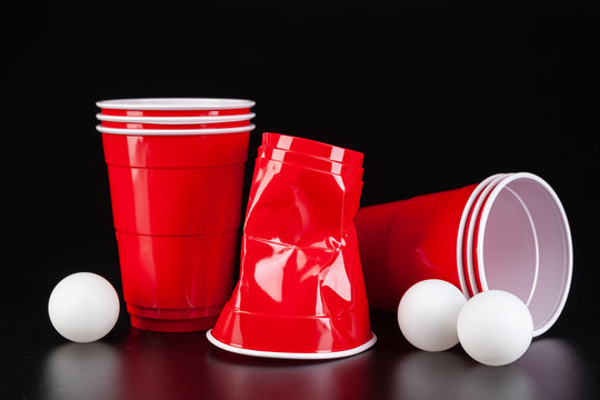 Red plastic cups and ball for game of beer pong